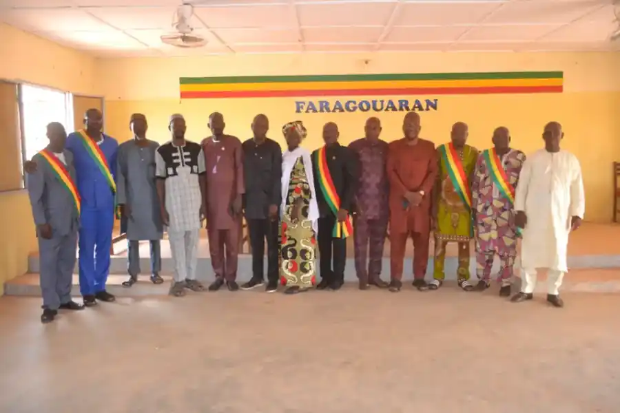 Élus et délégués des collectivités réunis devant le mur de la mairie de Faragouaran